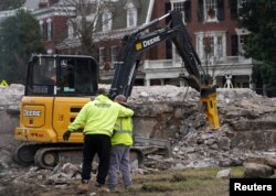 Workers react after the 1887 time capsule was removed from the former Robert E. Lee monument in Richmond, Virginia, Dec. 27, 2021.