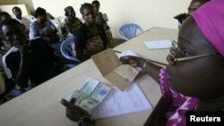 FILE - Town hall workers in Ivory Coast's main city, Abidjan, check through paperwork as people born in the West African state apply for birth certificates.