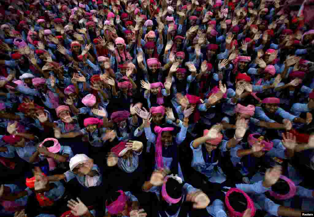 School girls wearing pink turbans wave during celebrations marking International Day of the Girl Child 2018, at a school in Chandigarh, India.