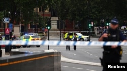 Armed police stand in the street after a car crashed outside the Houses of Parliament in Westminster, London, Britain, Aug. 14, 2018.