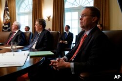 FILE - White House Chief of Staff Mick Mulvaney listens as President Donald Trump speaks during a cabinet meeting at the White House, Jan. 2, 2019, in Washington.