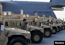 FILE - Ukrainian servicemen are seen after a welcoming ceremony for a plane from the United States with aid, including ten Humvee vehicles, at Borispil airport near Kyiv, March 25, 2015.