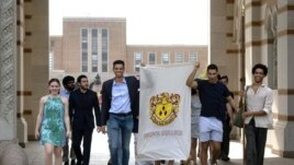 In this March 13, 2020 photo, seniors at Rice University parade through the school's main archway, known as the Sallyport, to continue a commencement tradition at the school in Houston.