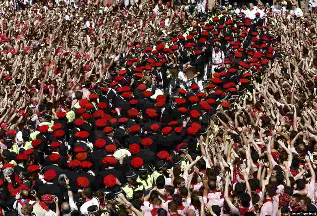 Bag pipers and drummers with red caps perform as thousands of people celebrate the beginning of the Sanfermines 2016 in Pamplona, northern Spain.