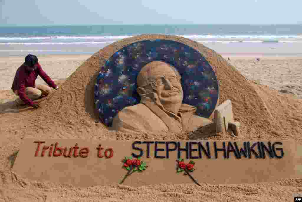 Sand artist Sudarsan Patnaik finishes a sculpture honoring British physicist and writer Stephen Hawking, at Puri beach, about 65 kilometers from Bhubaneswar, India. The renowned physicist died Wednesday at the age of 76.