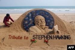 FILE - Sand artist Sudarsan Patnaik gives final touches to a sculpture in honor of British physicist and award-winning author Stephen Hawking at Puri beach, India, March 14, 2018.