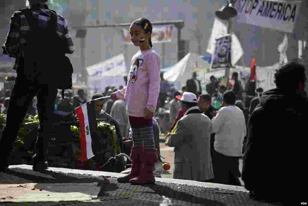 A young girl holds an Egyptian flag in Tahrir Square, November 30, 2012. (Y. Weeks/VOA)