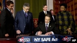Le gouverneur de New York Andrew Cuomo signe la loi sur le controle d'armes à feu et les munitions à New York et dans le droit lors d'une cérémonie dans la Salle Rouge au Capitole sur le mardi 15 janvier 2013, à Albany, New York 