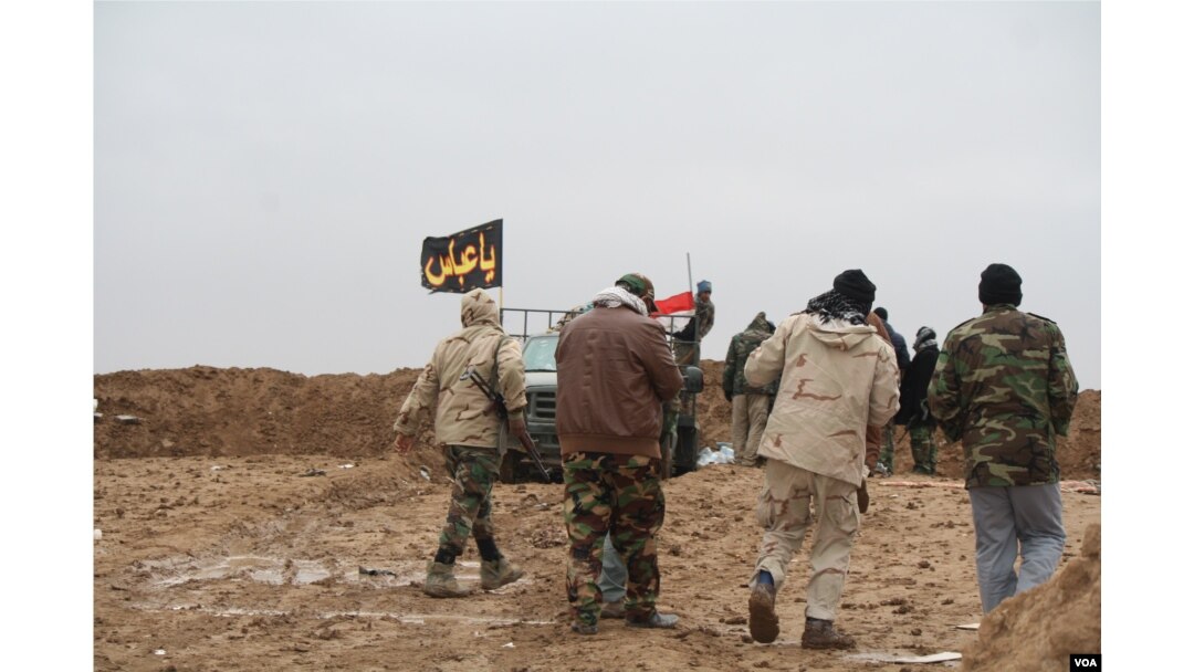 As the weather turns cold, and deserts turn into mud fields, predominantly Shia militias known locally as Hashd Shaabi, or Popular Mobilization forces, man berms against continued Islamic State attacks in Nineveh province, Iraq, Dec. 15, 2016. (H. Murdock/VOA)