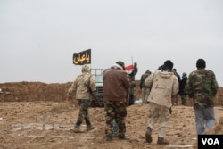 As the weather turns cold, and deserts turn into mud fields, predominantly Shia militias known locally as Hashd Shaabi, or Popular Mobilization forces, man berms against continued Islamic State attacks in Nineveh province, Iraq, Dec. 15, 2016. (H. Murdock/VOA)