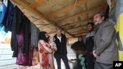 FILE - Jan Egeland, secretary-general of the Norwegian Refugee Council, listens to a Syrian family at a refugee camp in Marej, Lebanon.