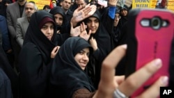 FILE - Iranian women demonstrators take a selfie while showing their hands.