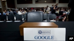 An empty chair reserved for Google's parent Alphabet, which refused to send its top executive, is seen as Facebook COO Sheryl Sandberg accompanied by Twitter CEO Jack Dorsey testify before the Senate Intelligence Committee hearing on 'Foreign Influence Operations and Their Use of Social Media Platforms' on Capitol Hill, Sept. 5, 2018, in Washington.