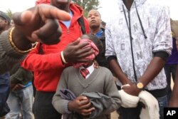 A man covers his daughter's face after she inhailed police teargas.