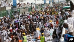 Muslim pilgrims and rescuers gather around the victims of a stampede in Mina, Saudi Arabia during the annual hajj pilgrimage on Thursday, Sept. 24, 2015.