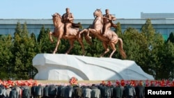 North Koreans bow to bronze statues of North Korea founder Kim Il-sung and late leader Kim Jong-il. (REUTERS/Kyodo) 