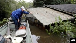 Florence, S.C., resident Jackie Lee surveys the flooding to his property along the Lynches River near Effingham, S.C., where houses and cars are swamped following record rainfall in the state, Oct. 6, 2015.