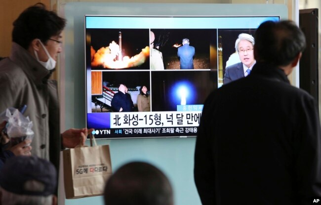 People watch a TV screen showing a local news program reporting about North Korea's missile launch, at the Seoul Railway Station in Seoul, South Korea, Nov. 30, 2017.