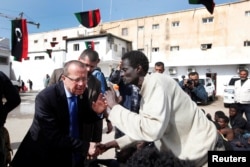 U.N. Special Representative and Head of the United Nations Support Mission in Libya, Martin Kobler listens to an African migrant during a visit to a detention camp in Tripoli, Libya, Feb. 21, 2017.