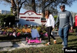 플로리다 마조리스톤맨더글러스 고등학교 총기난사 사건 1주년을 맞은 14일, 학교 입구에 희생자들을 추모하는 꽃과 메시지가 놓여있다.