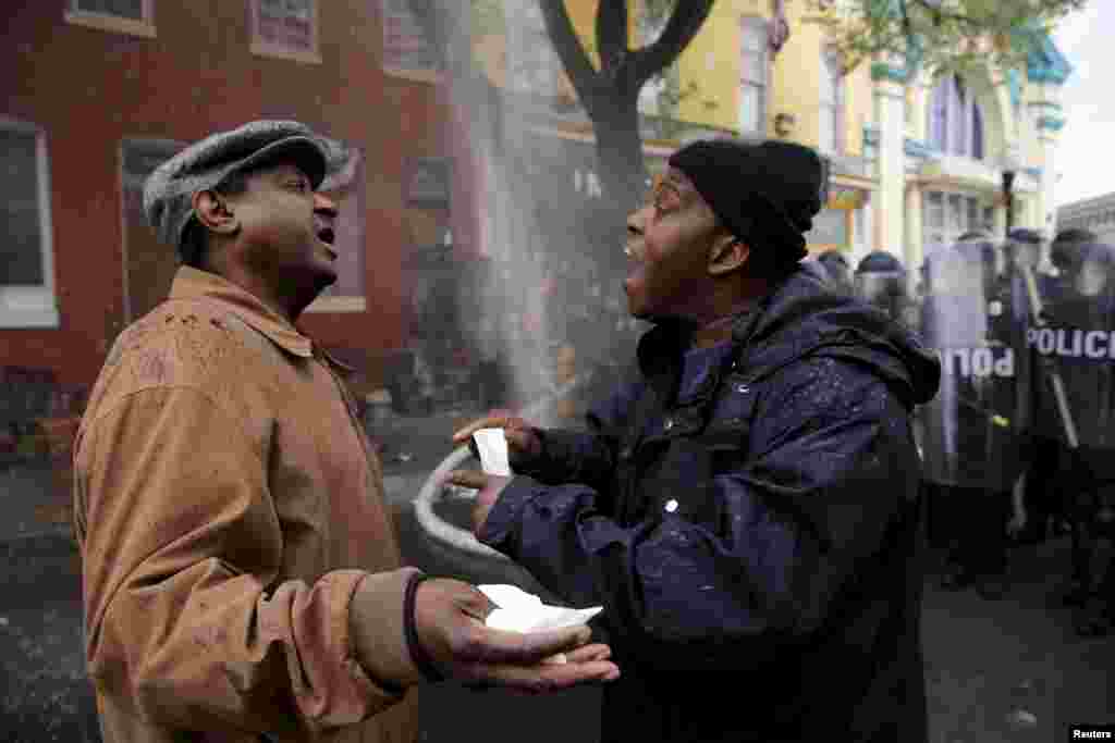 A Baltimore resident (R) trying to restore order in his neighborhood speaks to a protester during clashes in Baltimore, Maryland, April 27, 2015. 