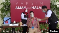 Indonesian influencer Raffi Ahmad receives a shot of the coronavirus disease (COVID-19) vaccine at the Merdeka Palace in Jakarta, Indonesia in a screen grab from January 13, 2021 handout video from Indonesian Presidential Palace via REUTERS. 