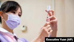 台灣行政院發布的照片​​顯示一名台灣醫護人員正在準備註射阿斯利康新冠疫苗。 （2021年3月22日）