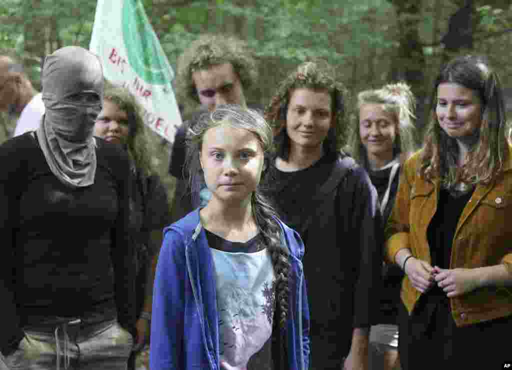 گرتا تونبرگ(نفر وسط)، نوجوان سوئدی و فعال سرشناس محیط زیست، هنگام بازدید از جنگل های باستانی غرب آلمان، در میان دیگر طرفداران حفظ محیط زیست