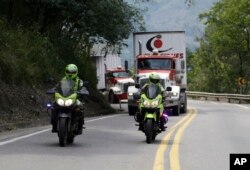 Two semi-trailer trucks containing humanitarian aid from the U.S for Venezuela are escorted by Colombian police in Los Patios, near Cucuta, Colombia, Feb. 7, 2019, about 18 miles from the Colombian-Venezuelan border.