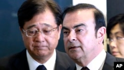 Nissan Motor Co. President and CEO Carlos Ghosn, right, and Mitsubishi Motors Corp. Chairman and CEO Osamu Masuko walk in the venue of their joint press conference in Yokohama, near Tokyo, Thursday, May 12, 2016.