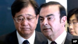 Nissan Motor Co. President and CEO Carlos Ghosn, right, and Mitsubishi Motors Corp. Chairman and CEO Osamu Masuko walk in the venue of their joint press conference in Yokohama, near Tokyo, Thursday, May 12, 2016.