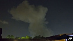A plume of smoke rises following an late-night airstrike in Tripoli, Libya, May 24, 2011