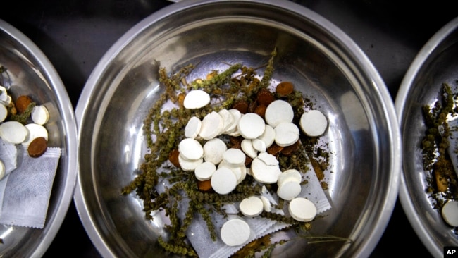 FILE - In this March 13, 2020 photo, traditional Chinese medicine remedies are being prepared at the Bo Ai Tang traditional Chinese medicine clinic in Beijing. (AP Photo/Mark Schiefelbein)