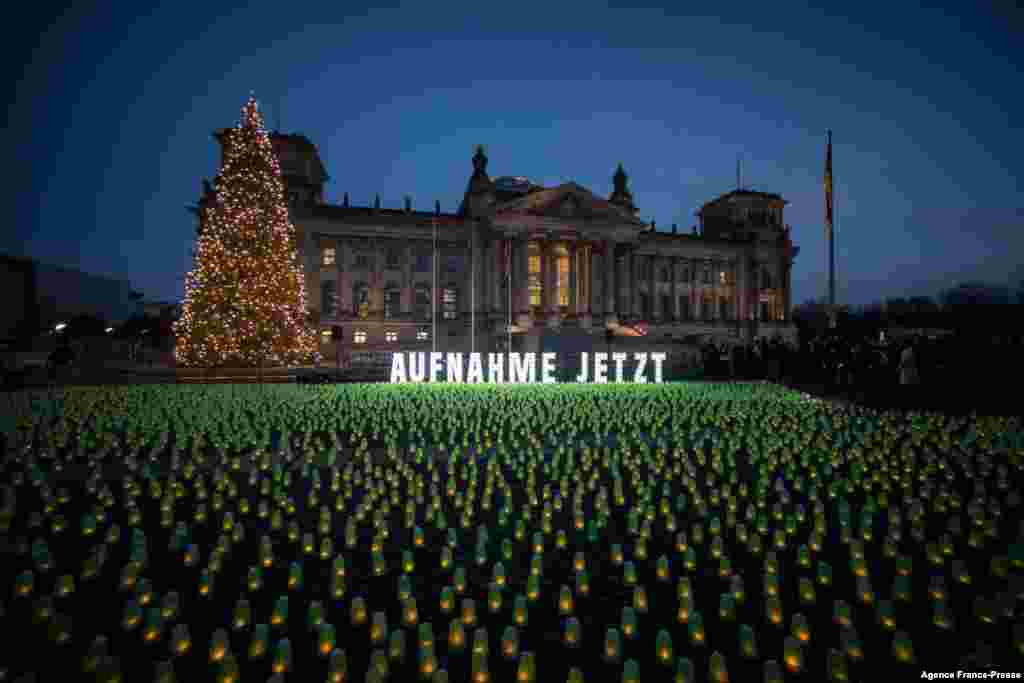 Candles are seen in front of the Reichstag building in Berlin, Germany, to draw attention to the refugees situation at the Polish-Belarusian border.