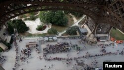 FILE - Visitors queue to visit the Eiffel Tower in Paris, France, June 2, 2018. A rule change earlier this month has meant even longer lines at the popular tourist spot.