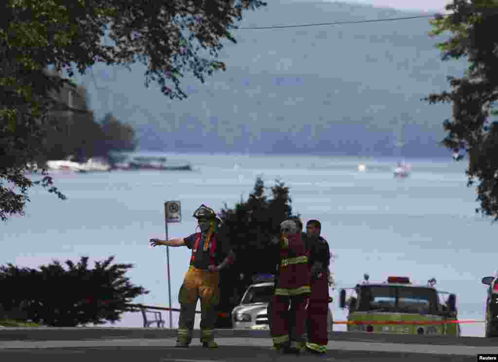 Firefighters continue to work in Lac Megantic, Quebec. Police erected an 8-foot (2.5-meter) fence blocking from view what was once a downtown core of restaurants, bars and shops - but which now resembles a blackened war zone after a train pulling 72 cars of crude oil jumped the track and exploded into flames on July 6.