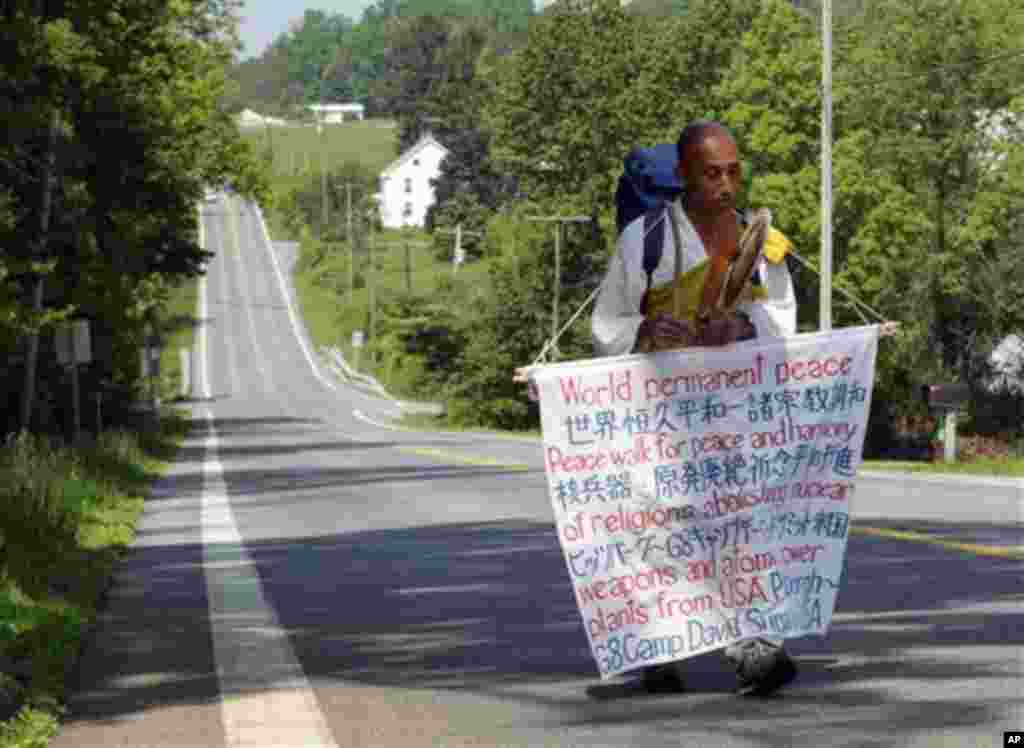 In a Wednesday, May 16, 2012 photo, Sekiguchi Toyoshige, a Japanese born Buddhist monk, walks along Route 77 west of Thurmont, Md. The peace activist was making his way towards Thurmont, Md. from Pittspurgh, PA to take part in peaceful protests during the