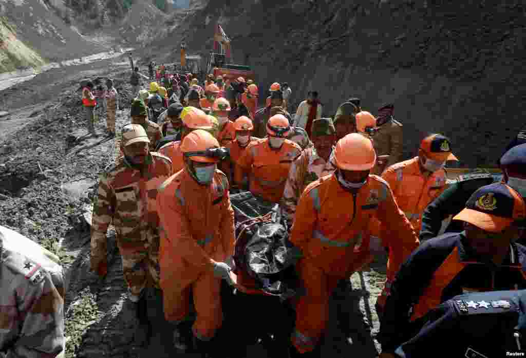 Members of National Disaster Response Force (NDRF) carry the body of a victim after recovering it from the debris during a rescue operation outside a tunnel after a part of a glacier broke away, in Tapovan in the northern state of Uttarakhand, India.