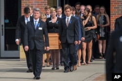 The casket of Otto Warmbier is carried from Wyoming High School after his funeral, June 22, 2017.