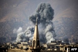 A picture taken on Nov. 23, 2017 shows smoke rising following a reported air strike on the rebel-held besieged town of Arbin, in the Eastern Ghouta region on the outskirts of Damascus.
