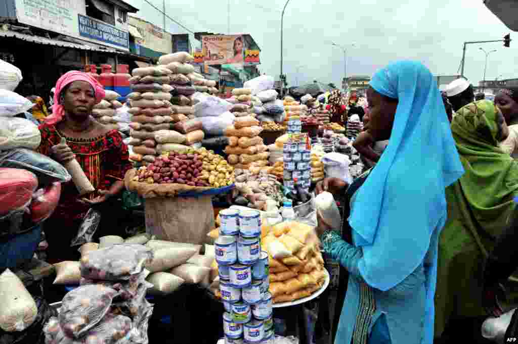 A woman shops for dates and cereals in a street market in Abobo, Ivory Coast, July 9, 2013.