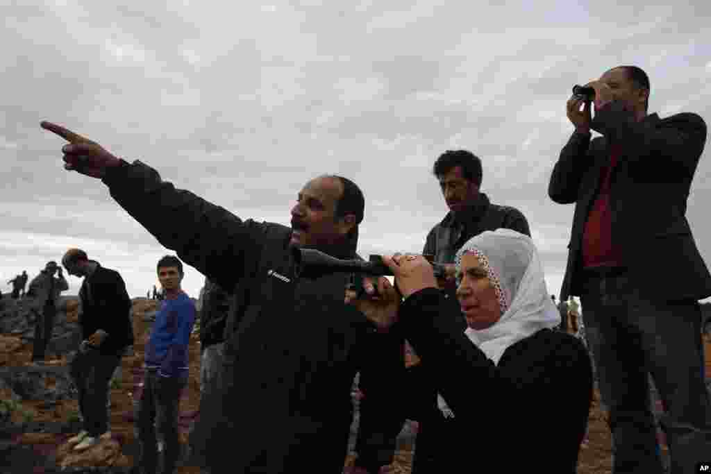 Turkiya-Suriya chegarasida odamlar Kobanidagi janglarni kuzatmoqda, 19-oktabr, 2014-yil. 
