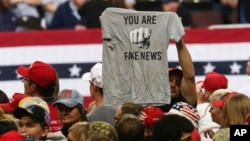 FILE - A Trump supporter holds a T-shirt reading "You Are Fake News" before a rally by President Donald Trump in Rochester, Minnesota, Oct. 4, 2018. Freedom House says that democracy in the U.S. weakened significantly and blames U.S. President Donald Trump for "ongoing attacks."