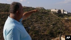 23일 레바논에서 한 남성이 이스라엘의 공습을 받은 반군 기지를 가리키고 있다.