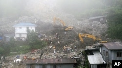 Rescuers and volunteers try to clear piles of garbage under thick fog in Baguio City, northern Philippines, August 29, 2011