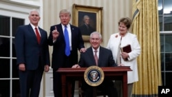 Le président Donald Trump, avec à sa gauche, le vice-président Mike Pence, et la femme de Tillerson à droite, après le serment du secrétaire d'État Rex Tillerson au Bureau ovale de la Maison-Blanche à Washington, 1er février 2017. 