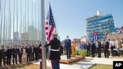 Menteri Luar Negeri AS John Kerry dan para pejabat lainnya menyaksikan penaikan bendera oleh para marinir di Kedutaan Besar AS di Havana, Kuba (14/8).
