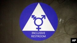 FILE - A sticker designates a gender neutral bathroom at Nathan Hale high school in Seattle, May 17, 2016.