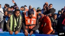 FILE - Migrants from Bangladesh, Afghanistan and Pakistan wait for being taken to the Spanish NGO Maydayterraneo's Aita Mari rescue boat during the rescue of 65 migrants in the Mediterranean international waters off the Libyan coast on February 10, 2020. (Pablo Garcia / AFP)