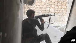 FILE - This undated photo posted Nov. 4, 2014 by the Raqqa Media Office of the Islamic State group - a militant extremist group, shows an Islamic state group fighter in Kobani, Syria. 